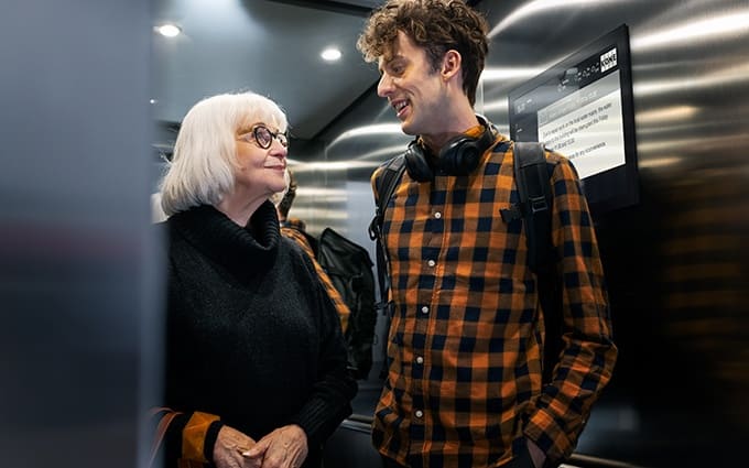 img_young_man_and_older_lady_in_residential_builings_elevator_680x425